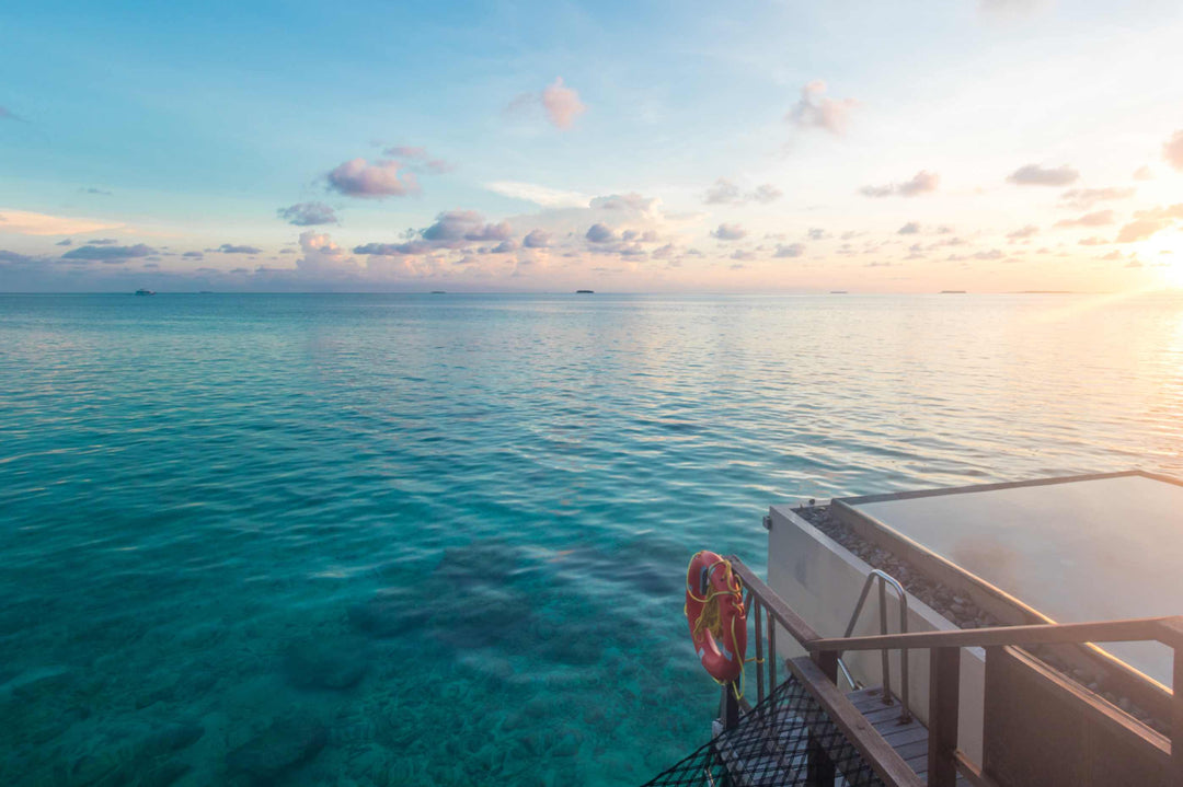 Sunset over the lagoon seen from a suite deck at Ayada Maldives