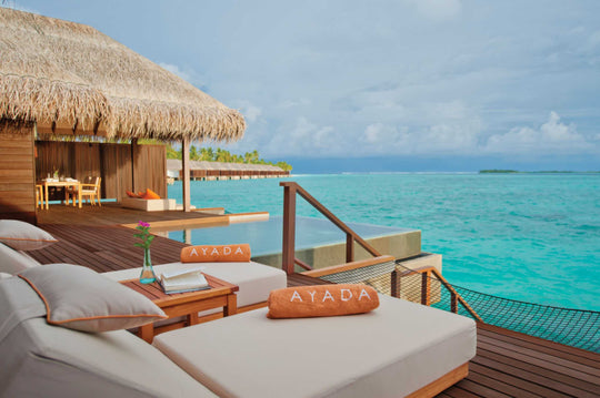 The deck of a sunset ocean suite at Ayada Maldives, daybed under thatch above the lagoon