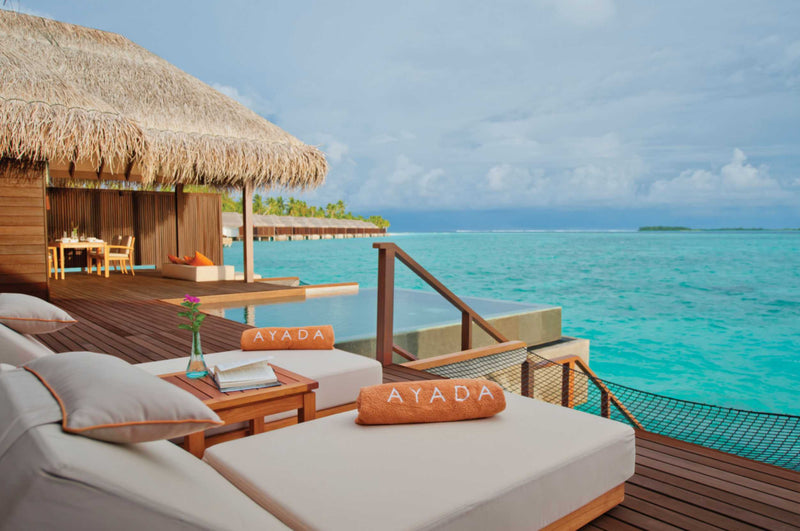 The deck of a sunset ocean suite at Ayada Maldives, daybed under thatch above the lagoon