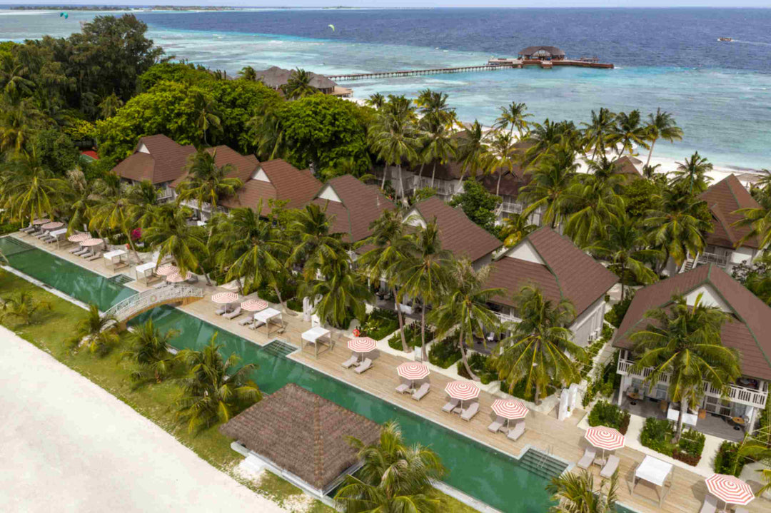 Sun Siyam Olhuveli, South Malé Atoll — aerial view of the pool, sun loungers and thatched roofs among the palms
