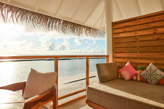 Sun Siyam Iru Veli, Dhaalu Atoll — covered deck with a daybed and sofa looking out over the lagoon