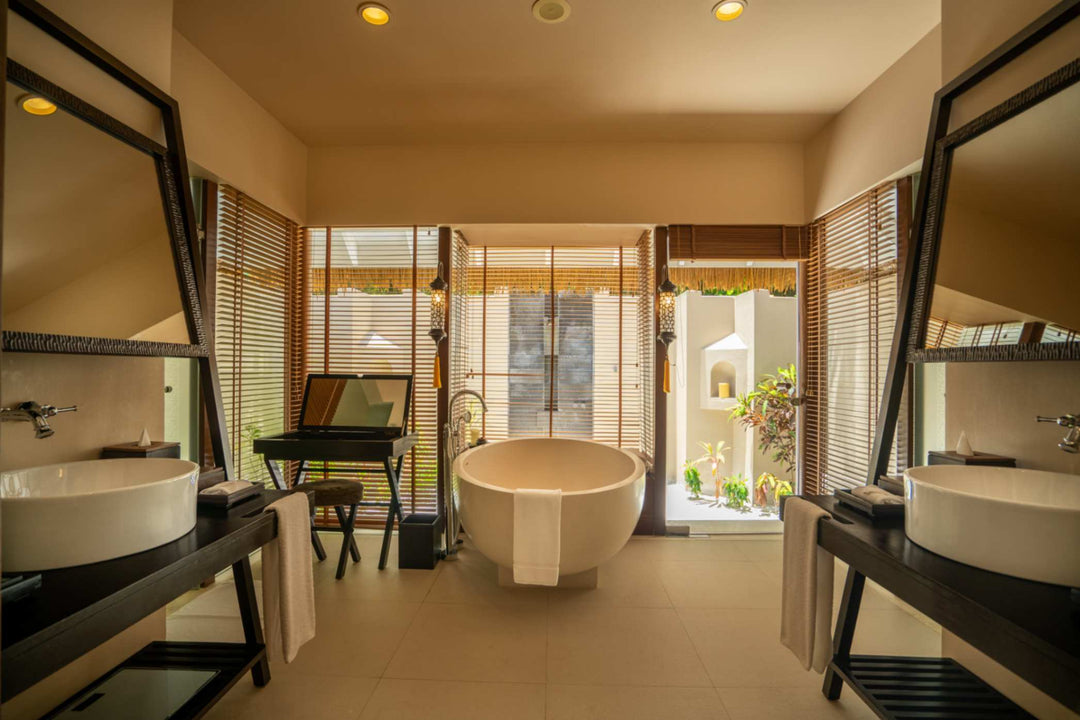 A beach villa bathroom at Ayada Maldives with a freestanding tub and twin basins
