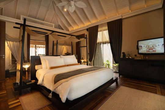 A bedroom in a family beach villa at Ayada Maldives, four poster bed facing the television