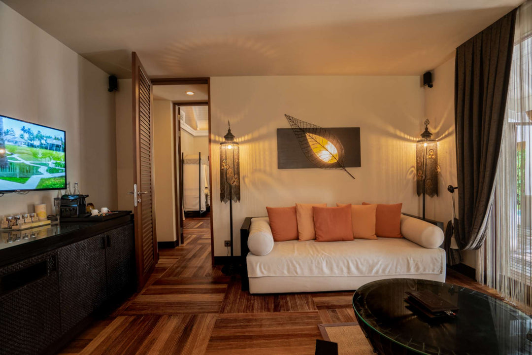 The living room of a family beach villa at Ayada Maldives, sofa and television with doors to the garden