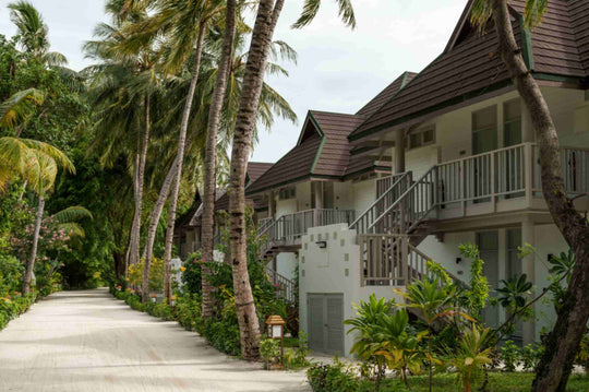 Sun Siyam Olhuveli, South Malé Atoll — two-storey Beach Pavilion buildings with external staircases, under palms