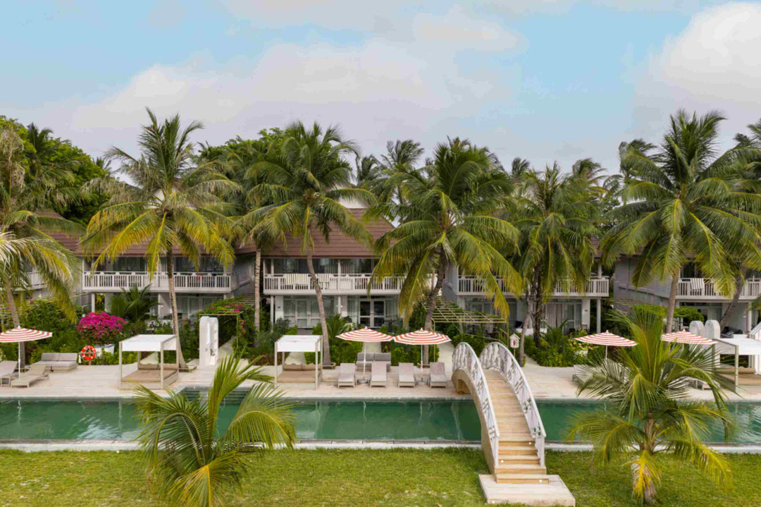Sun Siyam Olhuveli, South Malé Atoll — ornamental bridge crossing the long pool, with pavilion buildings behind