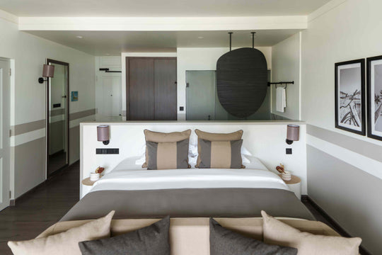 Sun Siyam Olhuveli, South Malé Atoll — king bed with the bathroom open behind it and framed prints on the wall