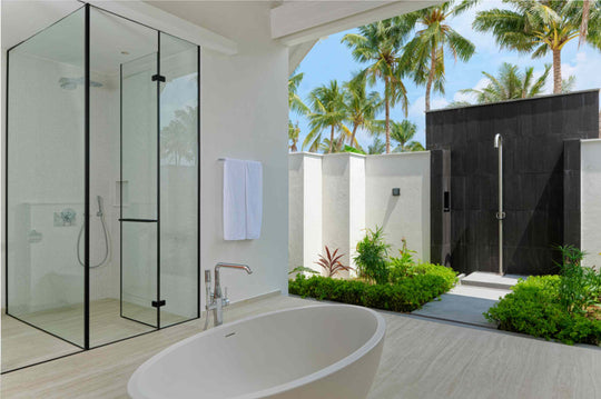 The outdoor shower of a Beach Villa at ananea Madivaru Maldives, planted and walled in dark timber