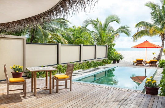 Angsana Velavaru, Dhaalu Atoll — the infinity pool of a Beachfront Infinity Pool Villa running towards the beach, with a table and chairs on the deck