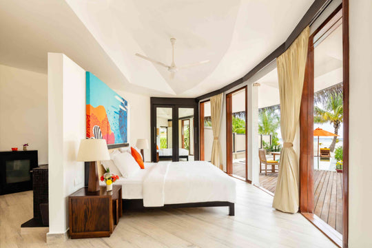 Angsana Velavaru, Dhaalu Atoll — beach villa bedroom with the doors folded back onto the pool deck