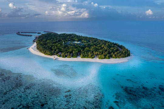 Ayada Maldives seen from far off, the island small against the open Indian Ocean