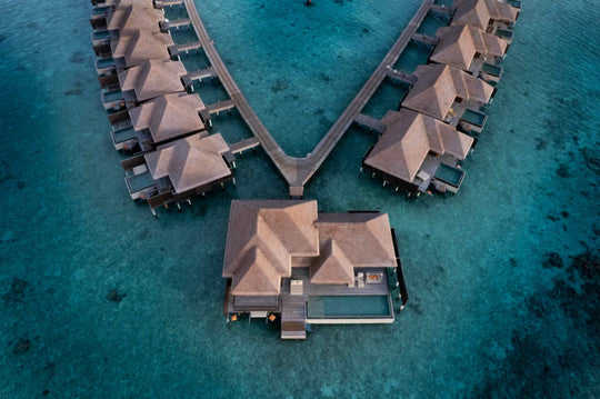 Two overwater villas at Ayada Maldives from directly above, thatched roofs and private decks