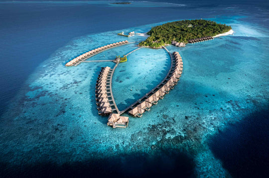 Ayada Maldives from the air, the island and both villa arms with the reef edge in view