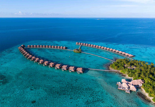Ayada Maldives seen from a distance in late light, the island low on the horizon