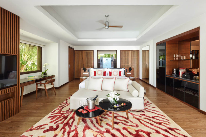 Bed and timber floor in a Deluxe Beach Pool Villa at Niyama Private Islands