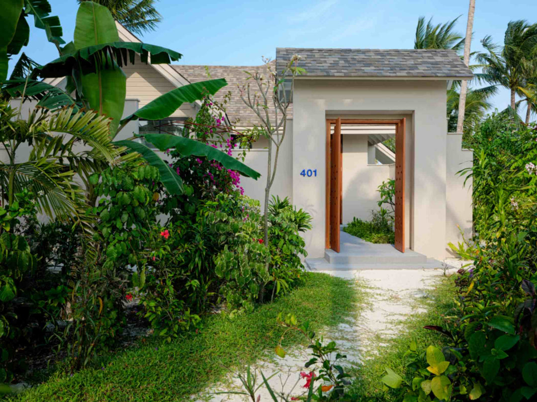 The entrance to a beach villa at ananea Madivaru Maldives, the villa number beside the door among flowering plants