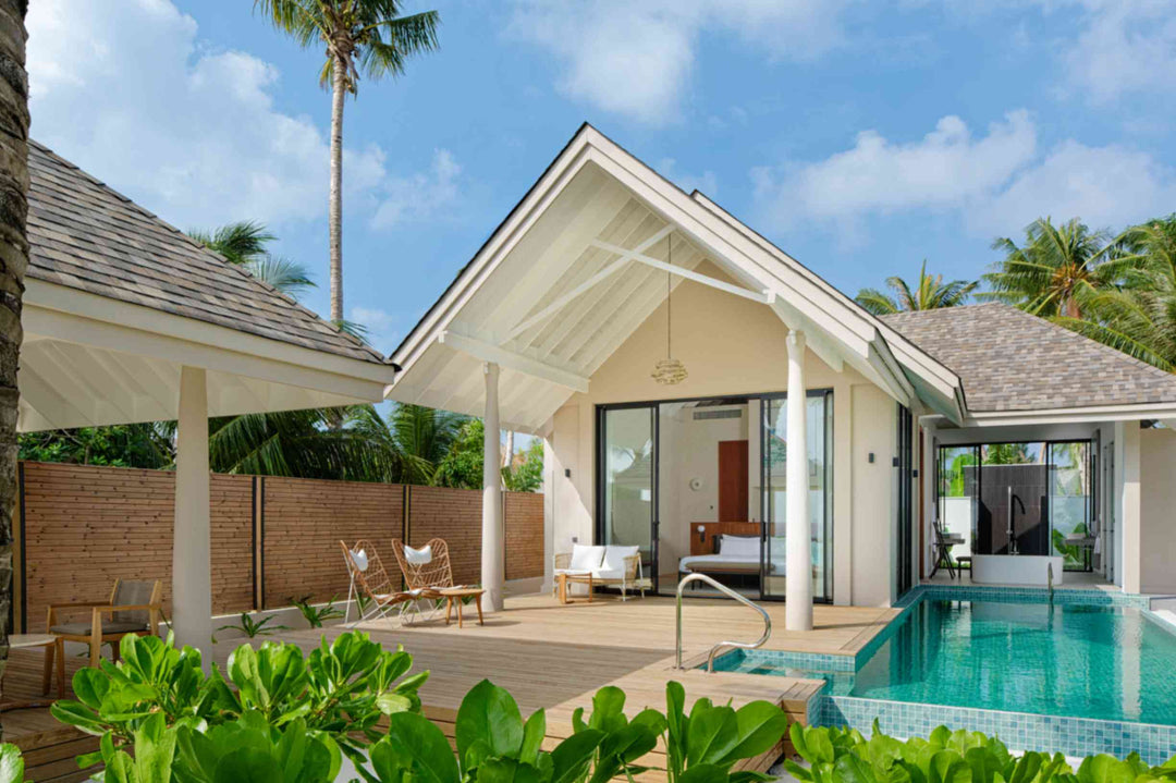A beach villa at ananea Madivaru Maldives from the garden, its pitched roof and glazed bedroom beside the pool