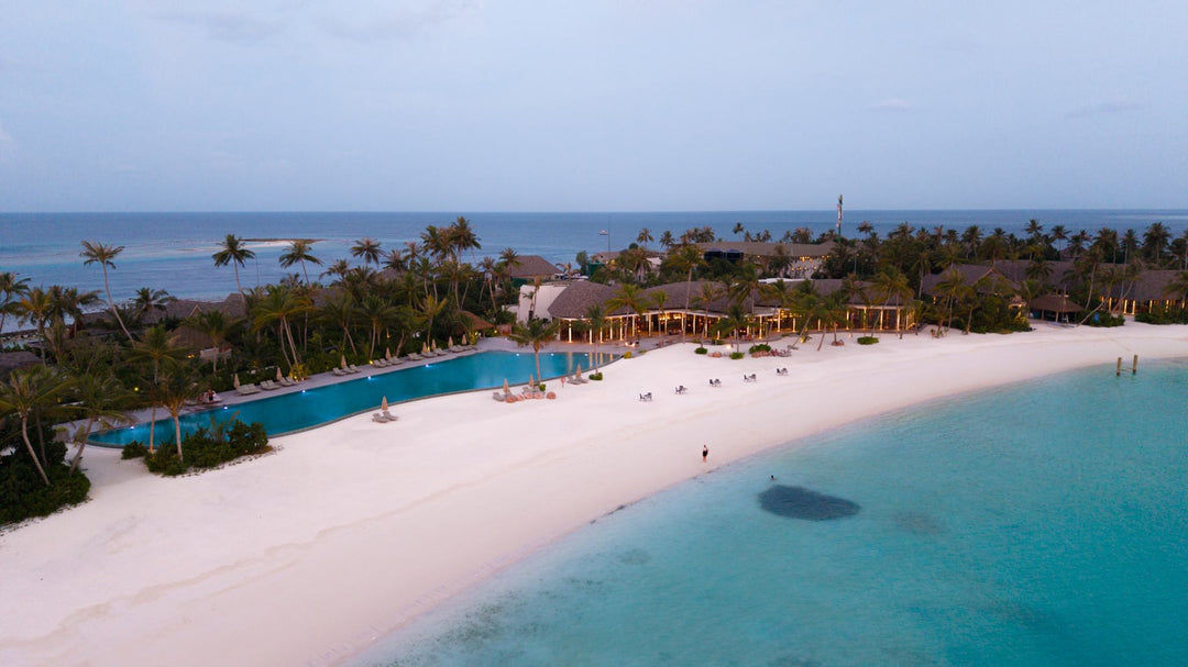 The main pool and beach at ananea Madivaru Maldives from the air, sun loungers along the sand