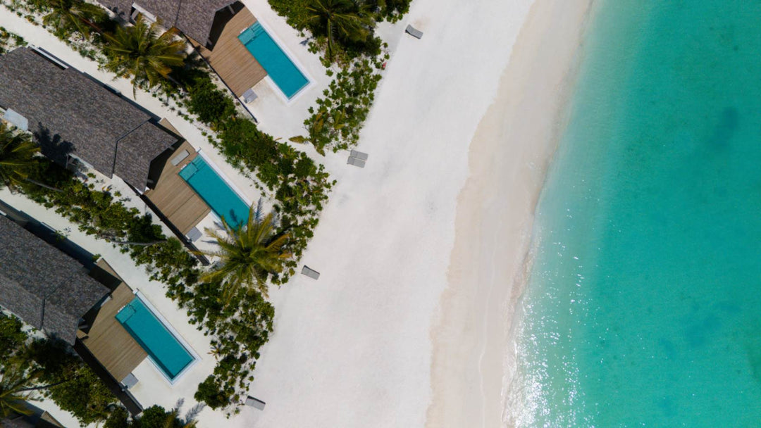 The beach side of ananea Madivaru Maldives from the air, villas and pools along the shoreline