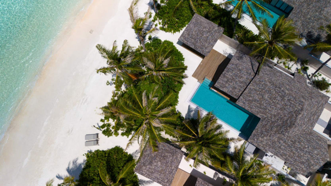 A beach villa at ananea Madivaru Maldives from directly above, its pool among the palms at the edge of the sand