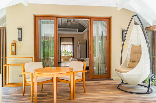 A garden villa terrace at Ayada Maldives, table and hanging chair in the shade