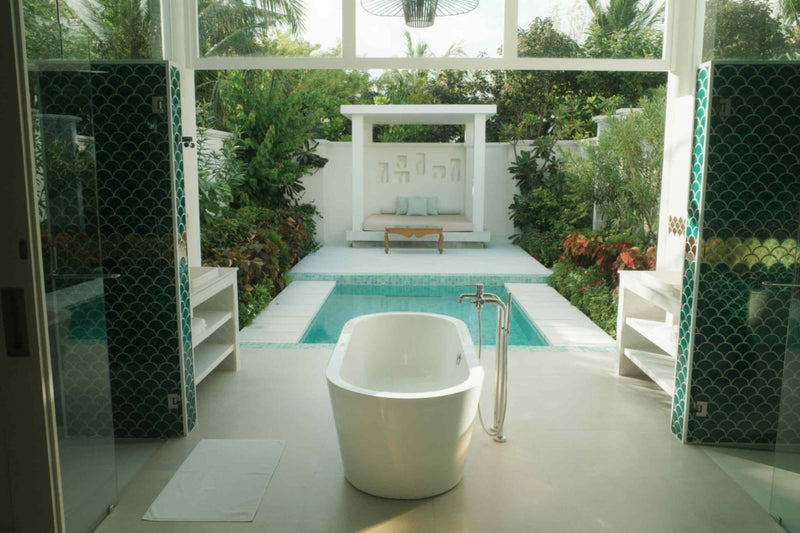 An open-air bathroom and private pool at Sun Siyam Iru Veli set in a walled garden.