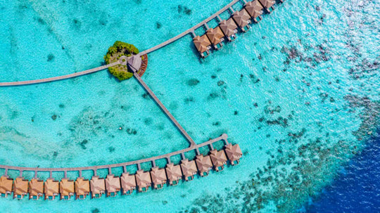 Overwater villas at Ayada Maldives with the small planted islet where the walkways meet