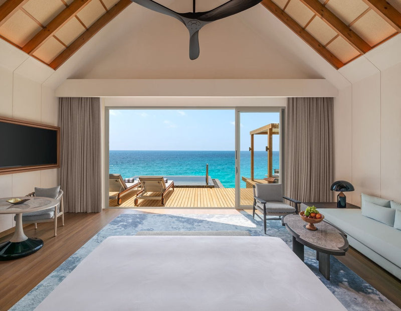 Overwater Villa interior opening onto its deck at JW Marriott Maldives Kaafu Atoll