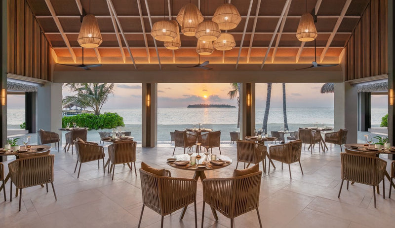 Restaurant tables at sunset, JW Marriott Maldives Kaafu Atoll