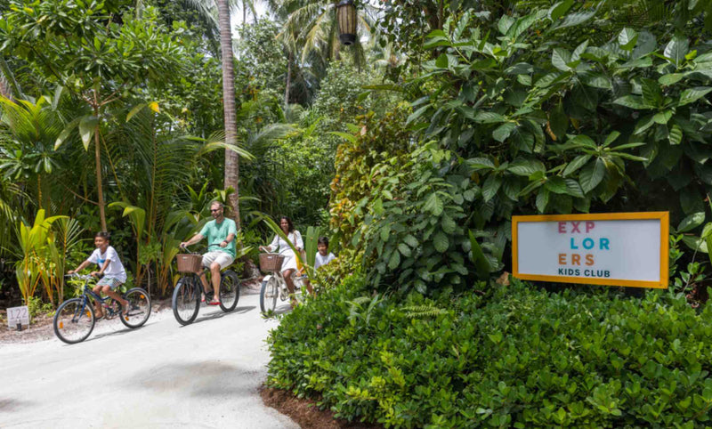 Family cycling together as part of the kids' club programme at Niyama Private Islands