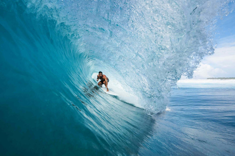 Surfer riding inside a breaking wave at the surf break off Niyama Private Islands