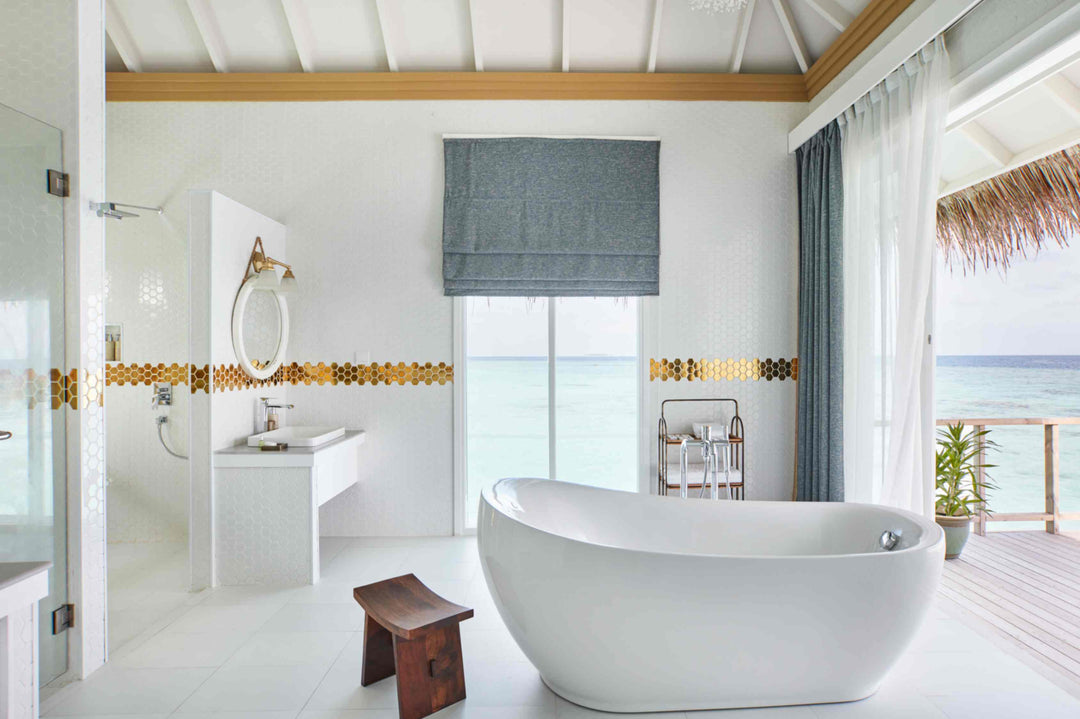 Sun Siyam Iru Veli, Dhaalu Atoll — overwater bathroom with a freestanding tub, walk-in shower and doors to the deck