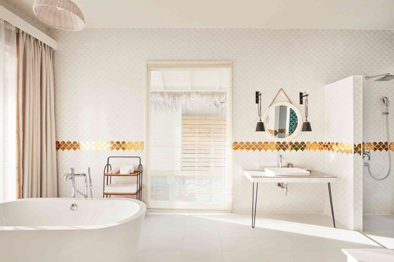 A bathroom at Sun Siyam Iru Veli with a freestanding tub, walk-in shower and a louvred door to the deck.