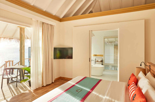 Sun Siyam Iru Veli, Dhaalu Atoll — overwater bedroom with a doorway through to the bathroom and the deck beyond