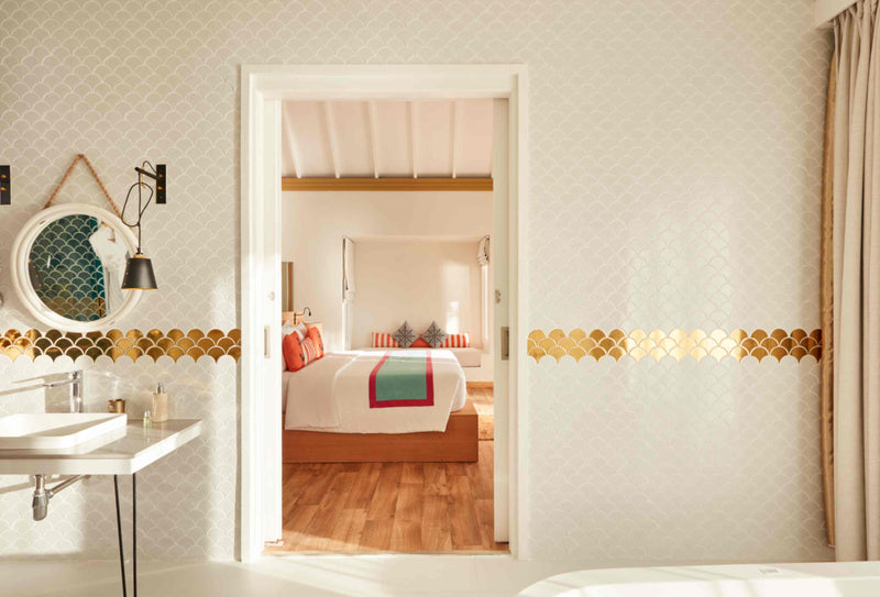 A bathroom at Sun Siyam Iru Veli looking through an open doorway to the bedroom.