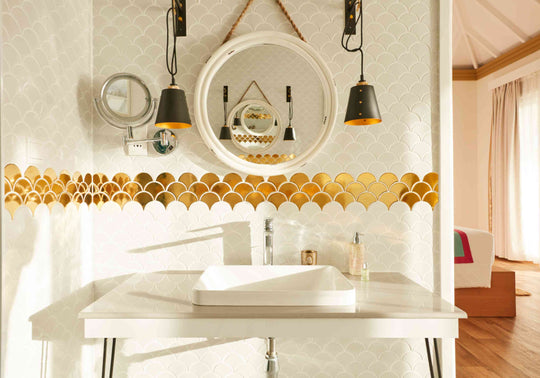 Sun Siyam Iru Veli, Dhaalu Atoll — bathroom vanity with a round mirror, pendant lights and a gold fish-scale tile band