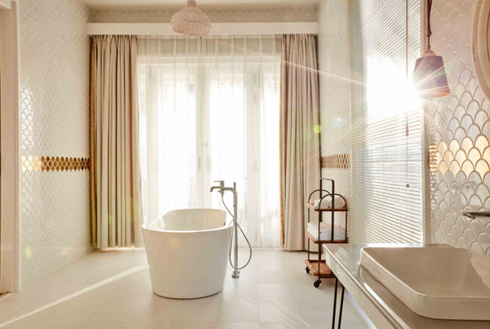 Sun Siyam Iru Veli, Dhaalu Atoll — bathroom with a freestanding tub in full sunlight beside a twin basin
