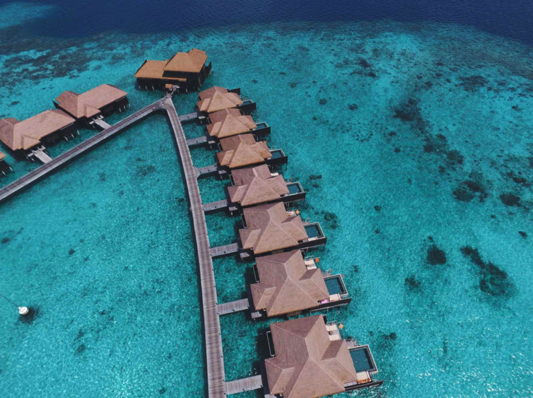 The overwater villas at Ayada Maldives from above, decks and ladders down to the water