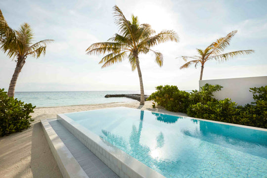 Sun Siyam Olhuveli, South Malé Atoll — private pool of a Grand Beach Suite with the sea beyond the palms