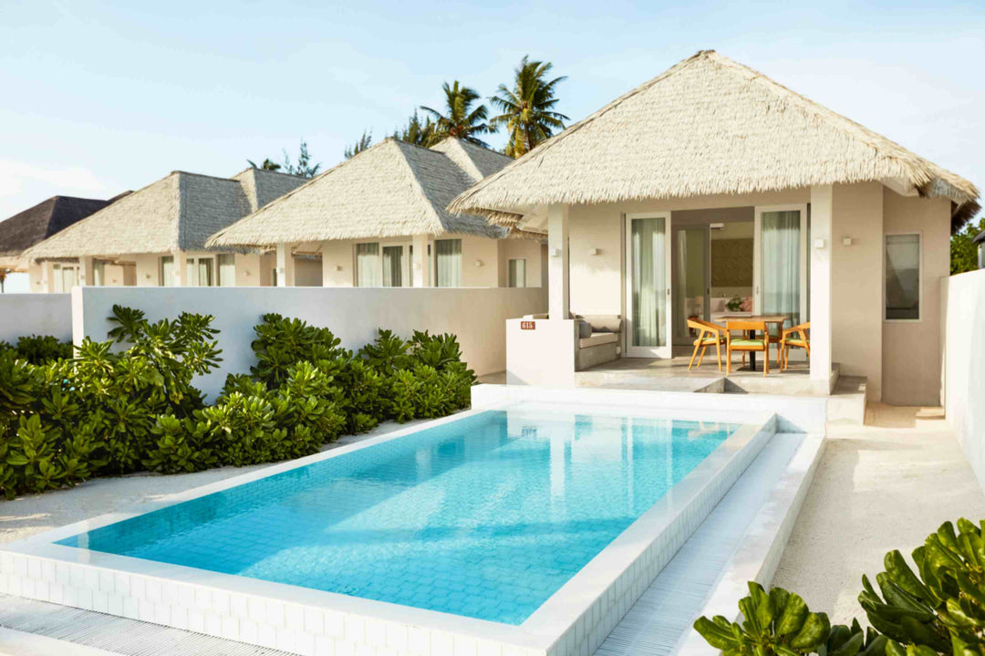 Sun Siyam Olhuveli, South Malé Atoll — private pool beside a thatched-roof suite in a walled garden