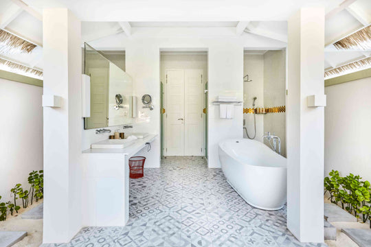 Sun Siyam Olhuveli, South Malé Atoll — suite bathroom with a freestanding bath, twin basins and patterned floor tiles
