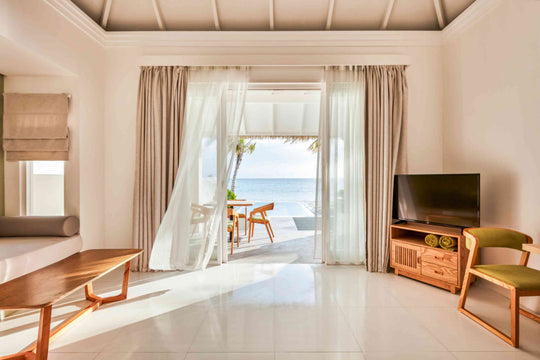 Sun Siyam Olhuveli, South Malé Atoll — suite living room looking through open doors to the sea