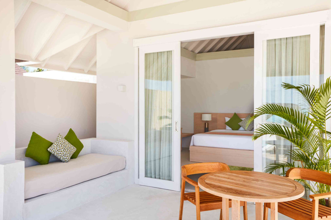 Sun Siyam Olhuveli, South Malé Atoll — daybed on the terrace looking into the bedroom, with a dining table alongside