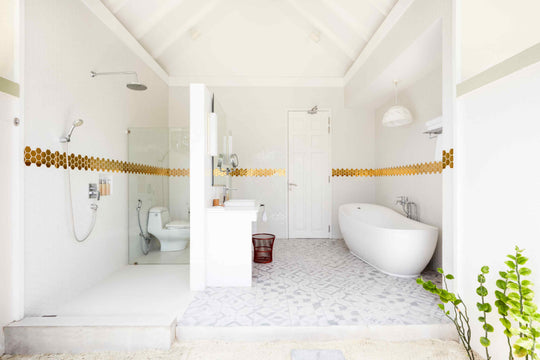 Sun Siyam Olhuveli, South Malé Atoll — beach villa bathroom with a freestanding bath and a gold mosaic band