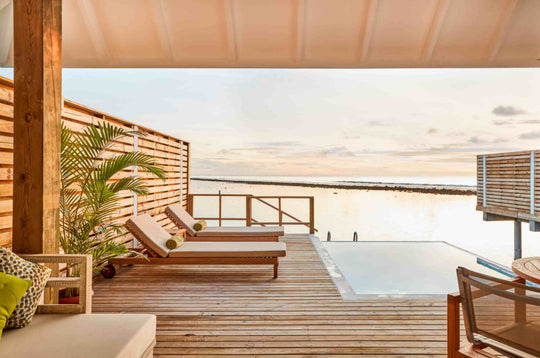 Sun Siyam Olhuveli, South Malé Atoll — plunge pool and loungers on an overwater deck at sunset