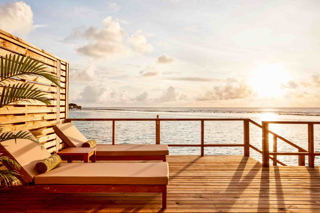 Sun Siyam Olhuveli, South Malé Atoll — overwater deck with sun loungers at sunset