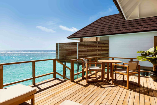 Sun Siyam Olhuveli, South Malé Atoll — table and chairs on the deck above turquoise water