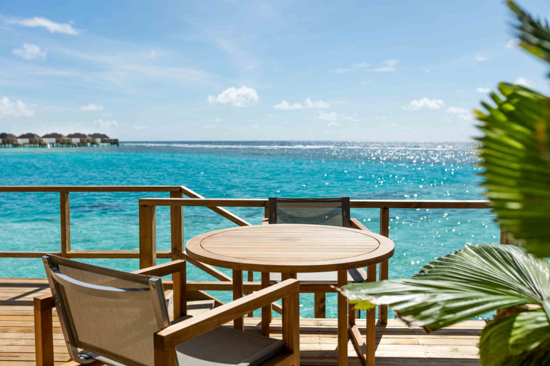 Sun Siyam Olhuveli, South Malé Atoll — deck table looking across the lagoon to the overwater villas
