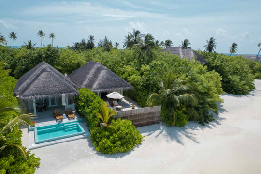 Sun Siyam Iru Veli, Dhaalu Atoll — aerial view over the thatched villa roofs, palms and the beach