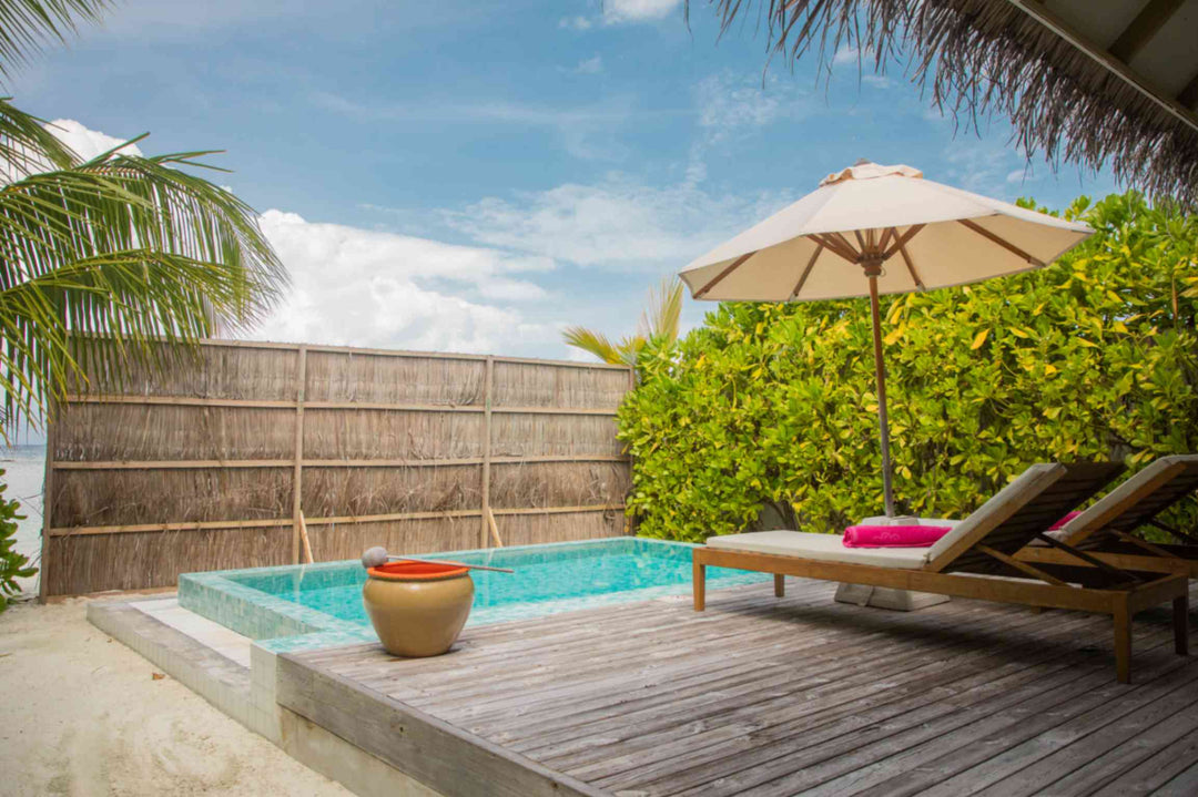 Sun Siyam Iru Veli, Dhaalu Atoll — pool deck with a parasol behind a bamboo privacy screen
